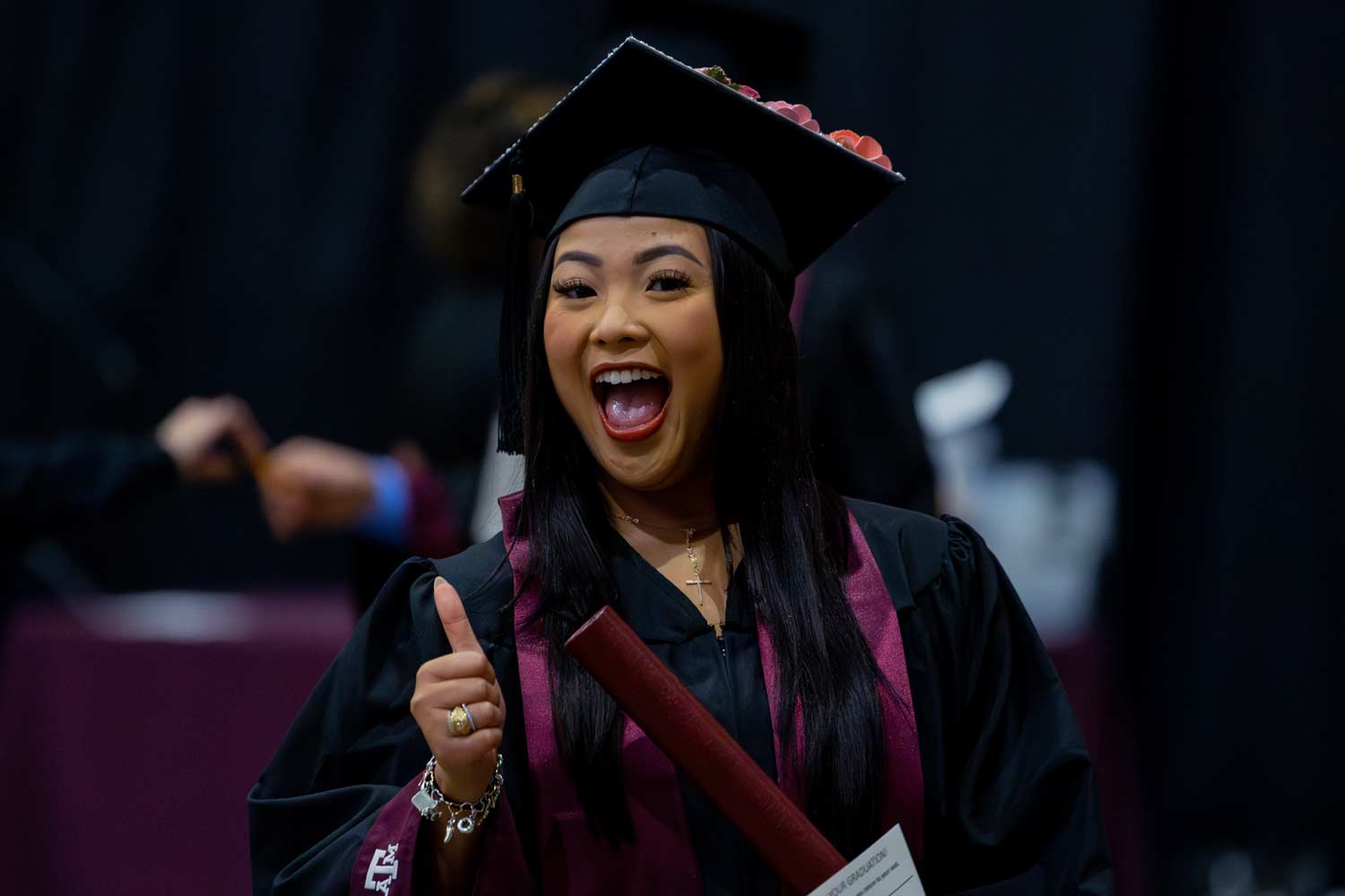 Student smiles and poses for a photo after walking the stage at graduation