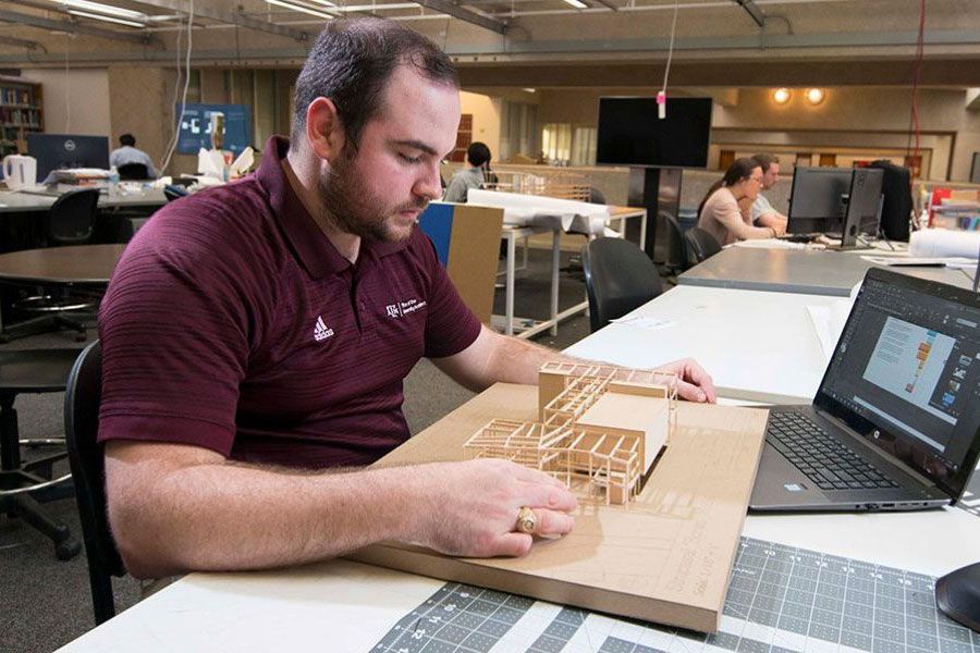 School of Architecture students looks over his class project of a building model