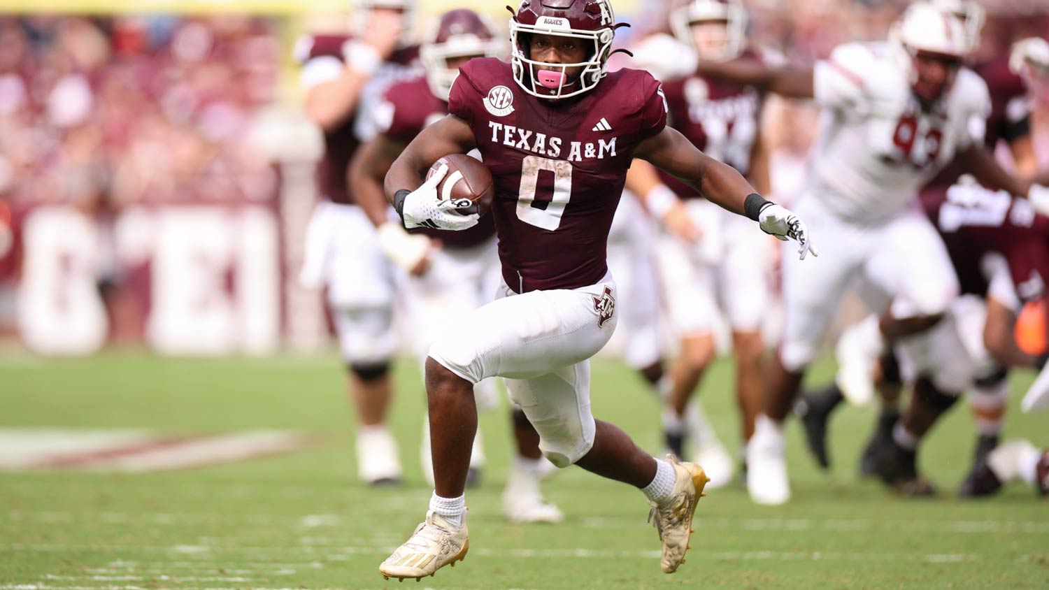 A Texas A&M football player runs with the football