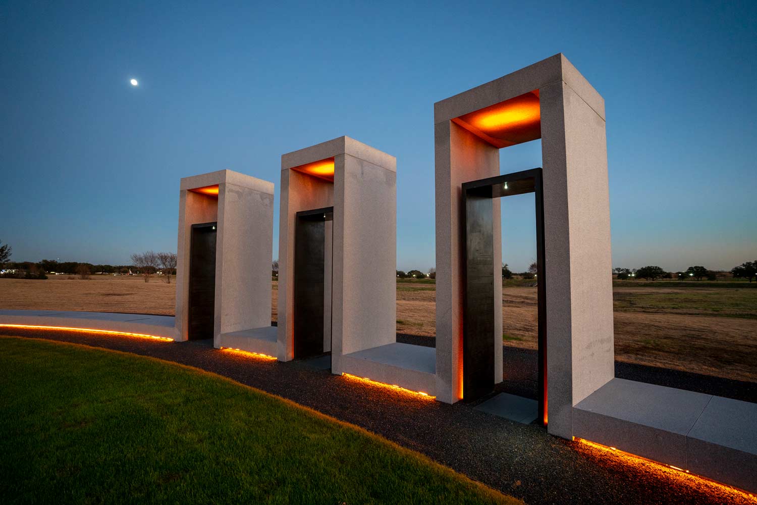 Three of the bonfire memorial pillars lit up at sunset