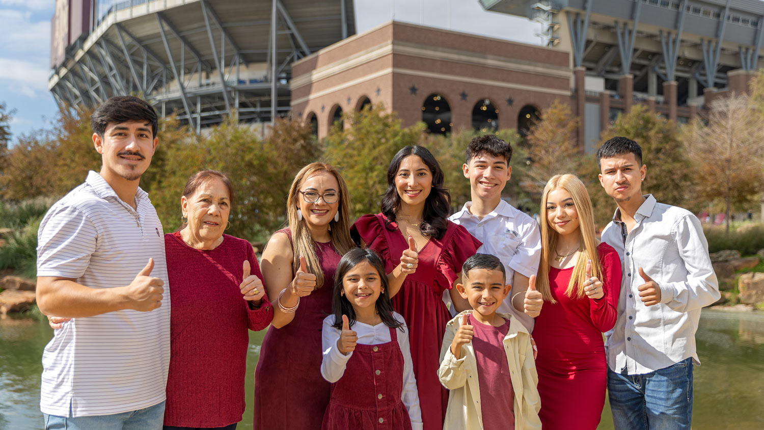 An Aggie on their Ring Day poses with their family in front of Kyle Field