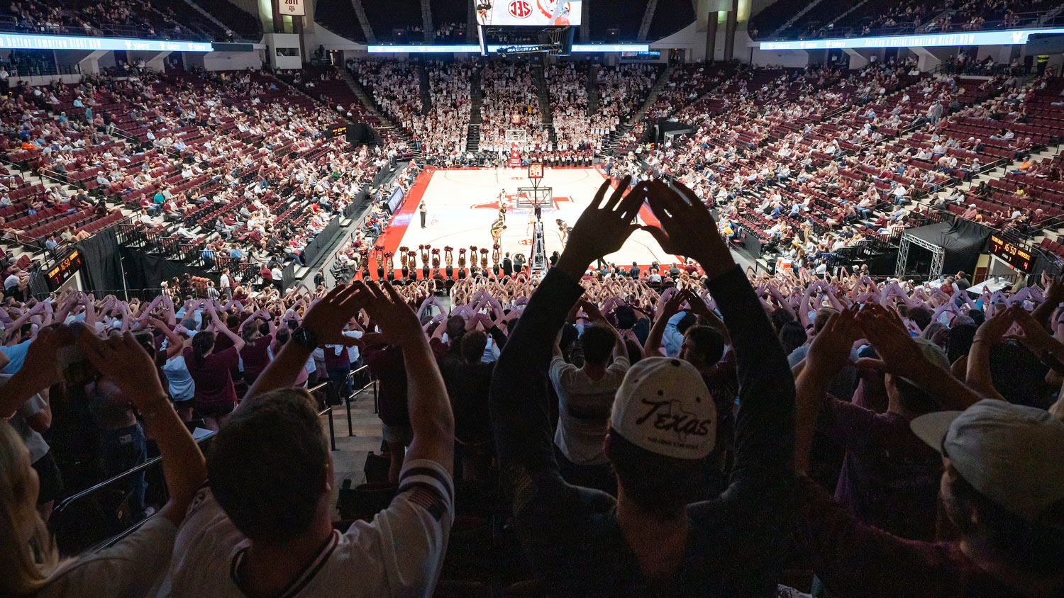 View of a Texas A&M basketball game from the top of the stands behind cheering fans