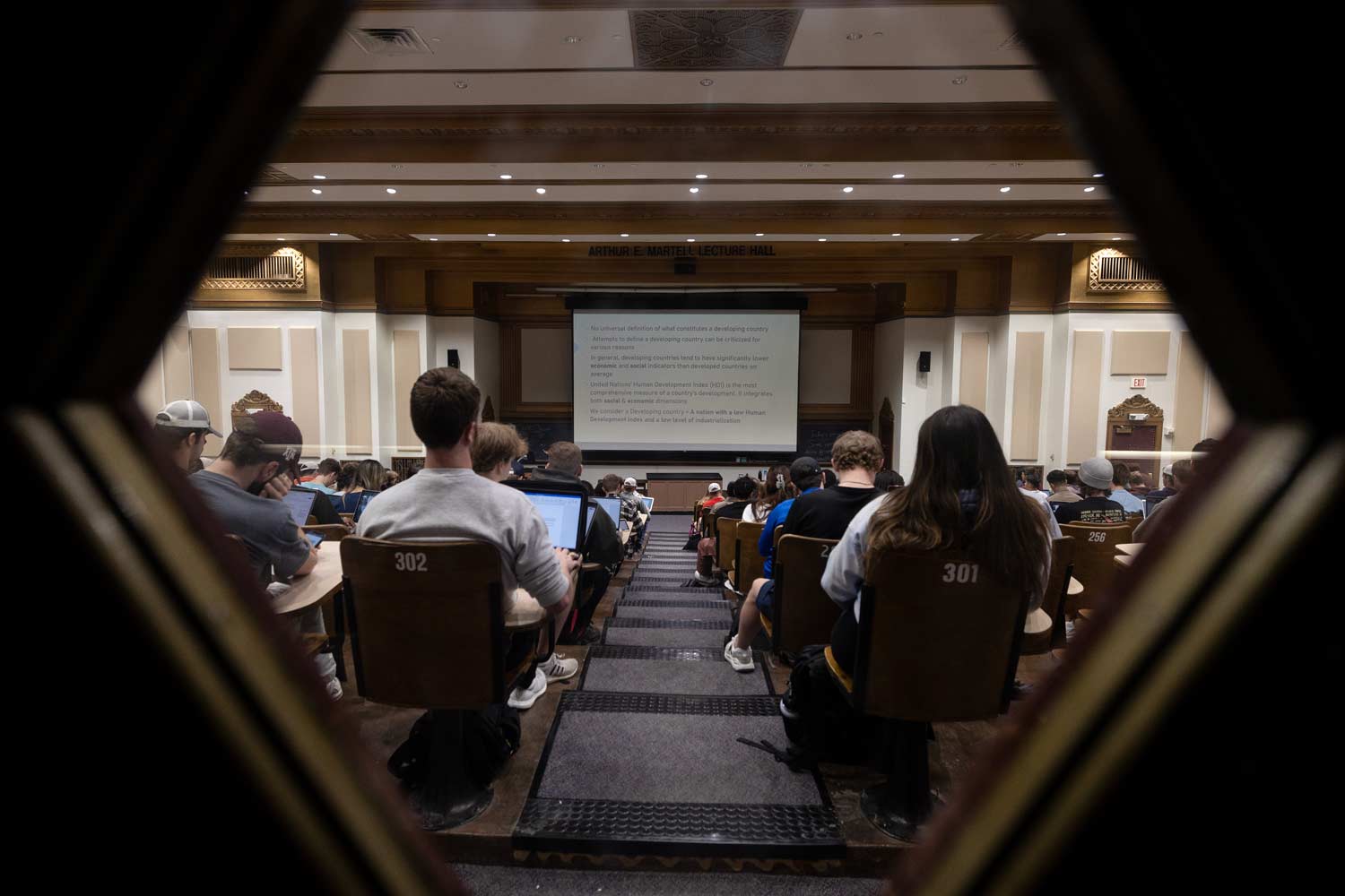 Looking through a window at a packed Texas A&M University lecture hall