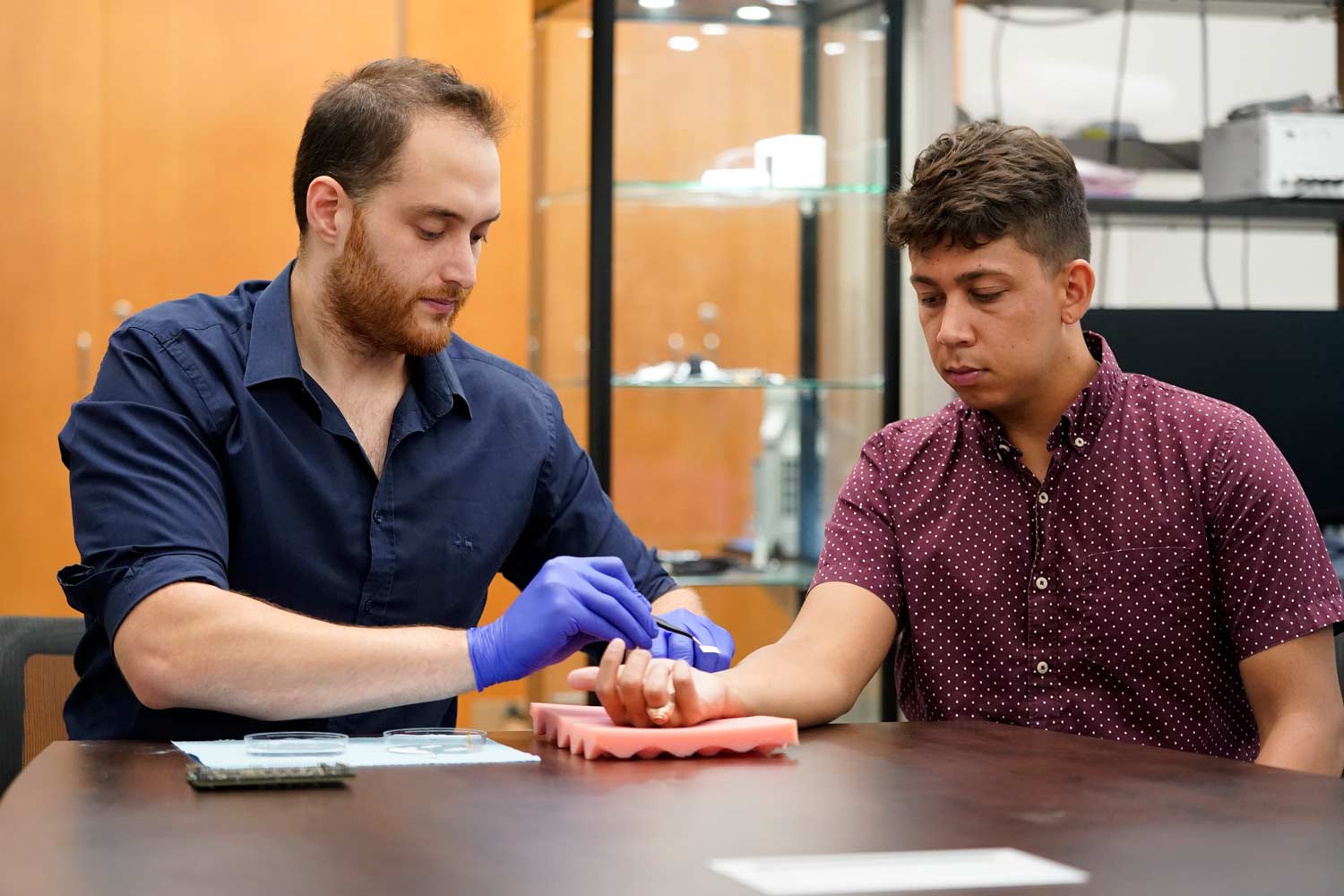 Student demonstrating the adminstration of an e-tattoo on a student's wrist.