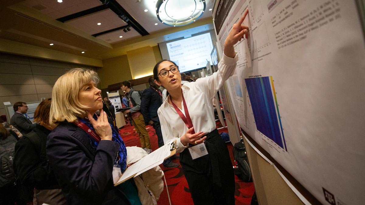 Texas A&M student presents her poster to a judge at the Undergraduate Research Symposium