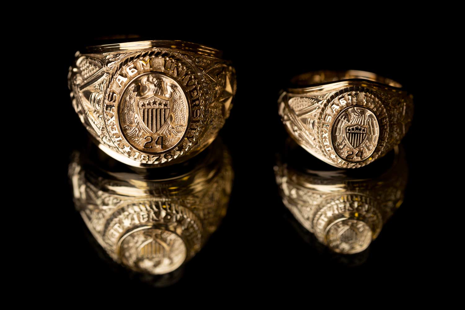 Two Aggie Rings sit side by side, comparing the size of the mens and womens rings