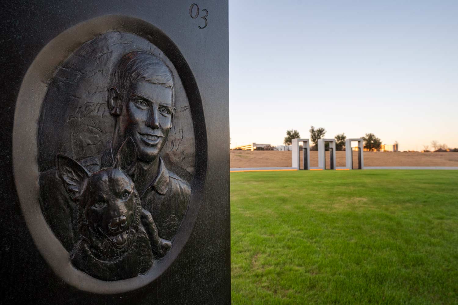 Portrait of a smiling Aggie and a dog engraved in stone at the Bonfire Memorial.