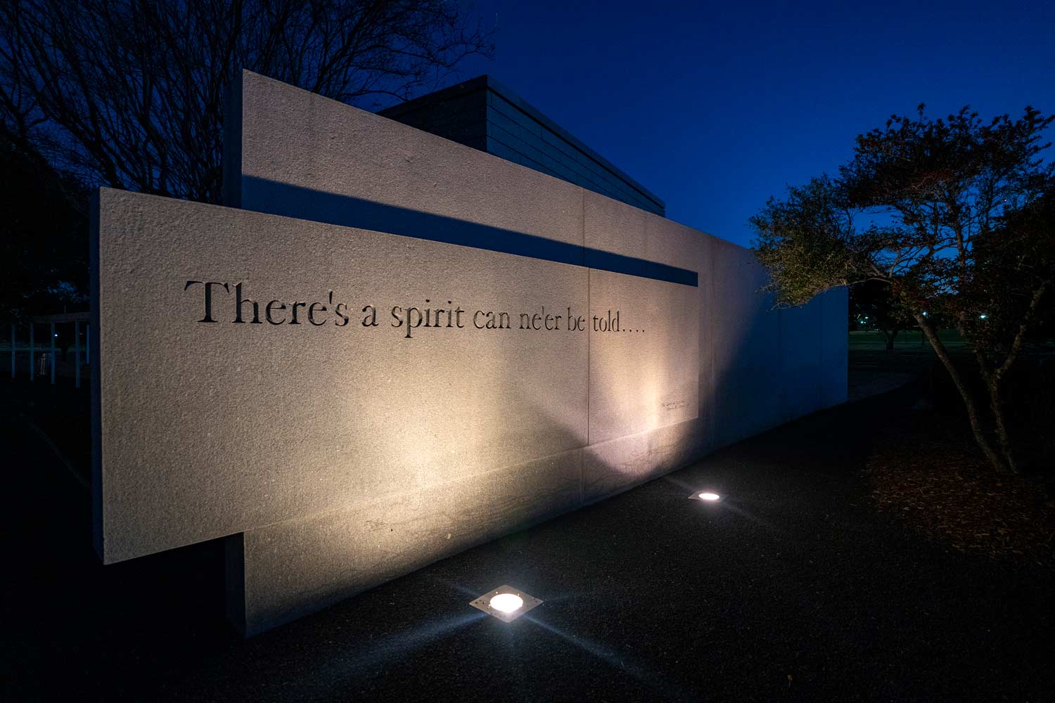 Engraved stone wall reading, "There's a spirit can ne'er be told..."