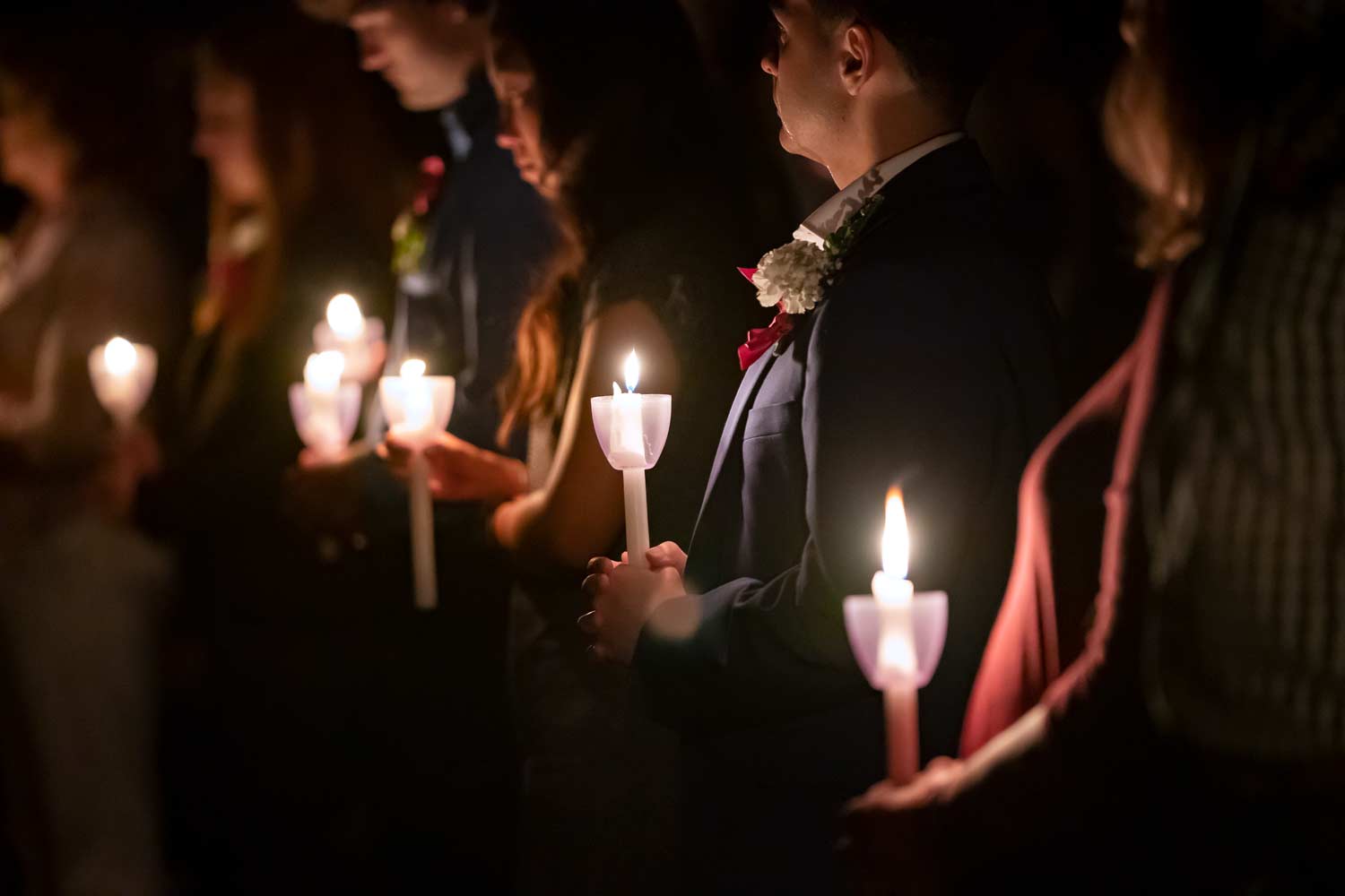 Aggies holding lit candles at Muster.