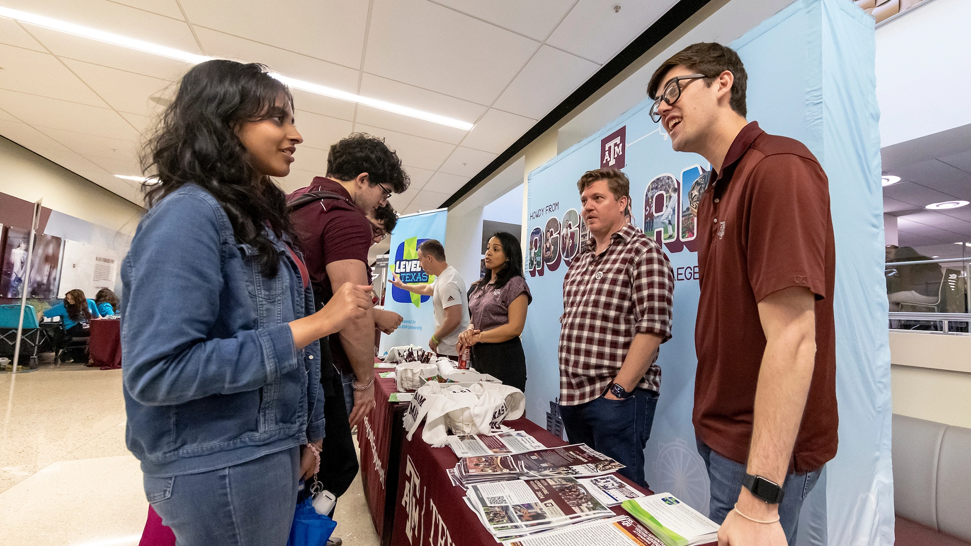 Students engaging at a university information booth showcasing educational opportunities.