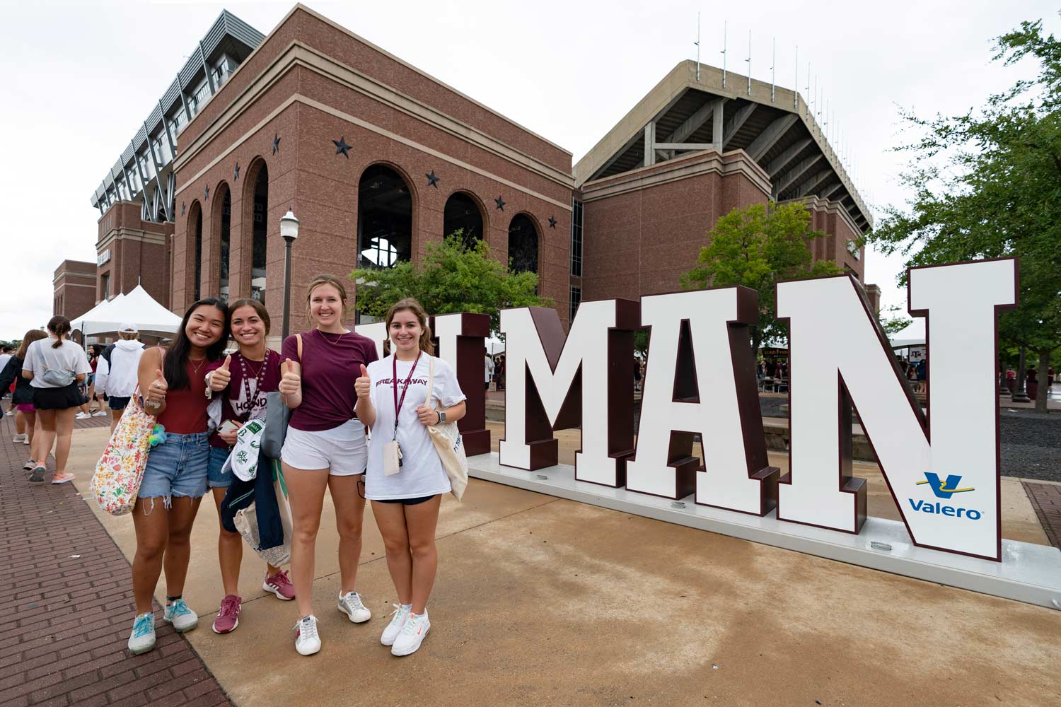 Aggie Students posing in front of the 12th Man sign at fish fest