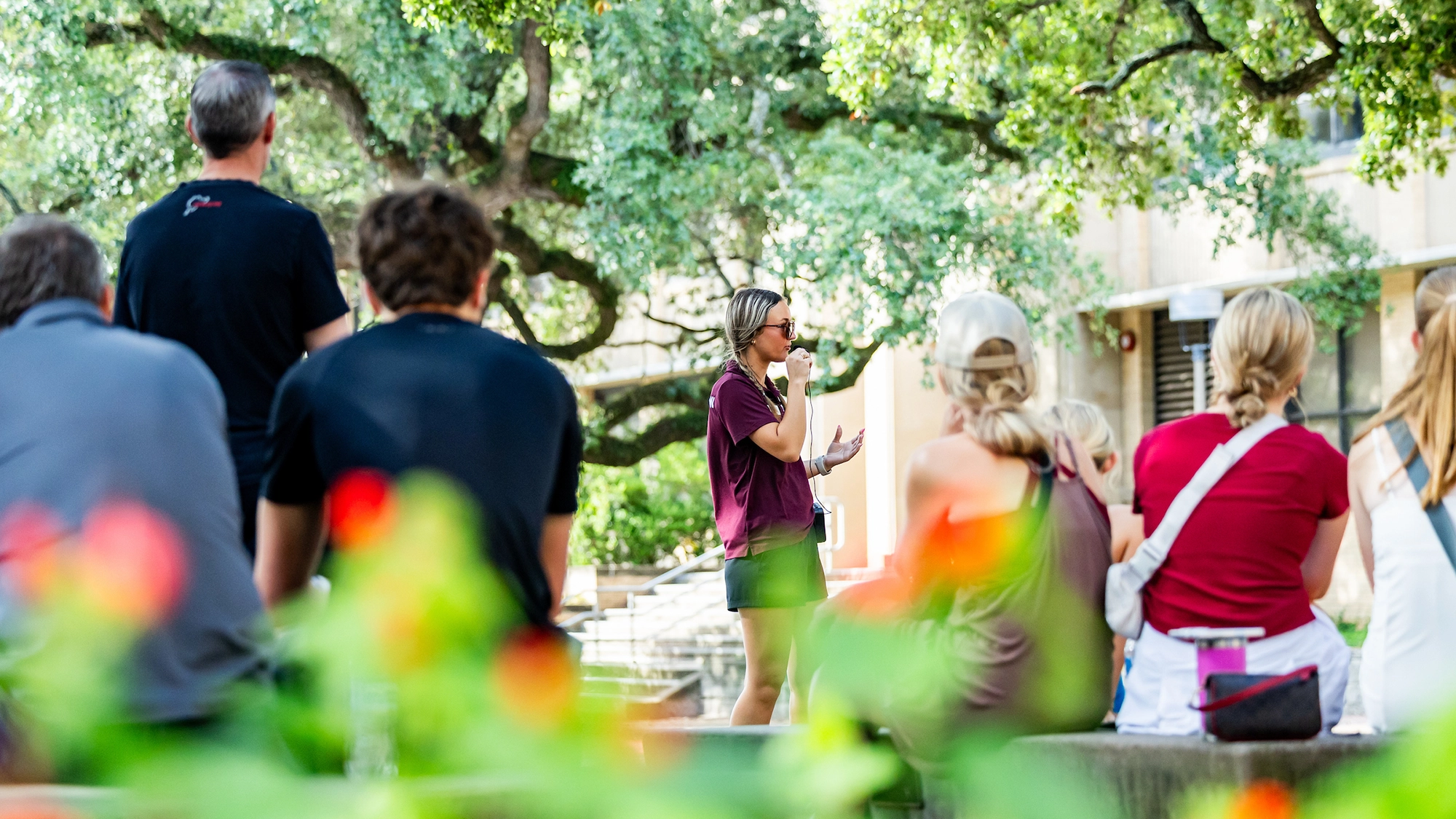 Prospective Texas A&M students listening to a tour group on campus