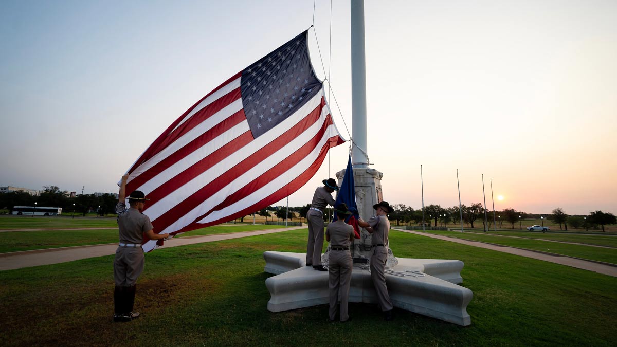 Members of the Corps of Cadets from A-Battery and C-Battery raise the U.S. and Texas flags outside of the Jack K. Williams Administration Building at Texas A&M University