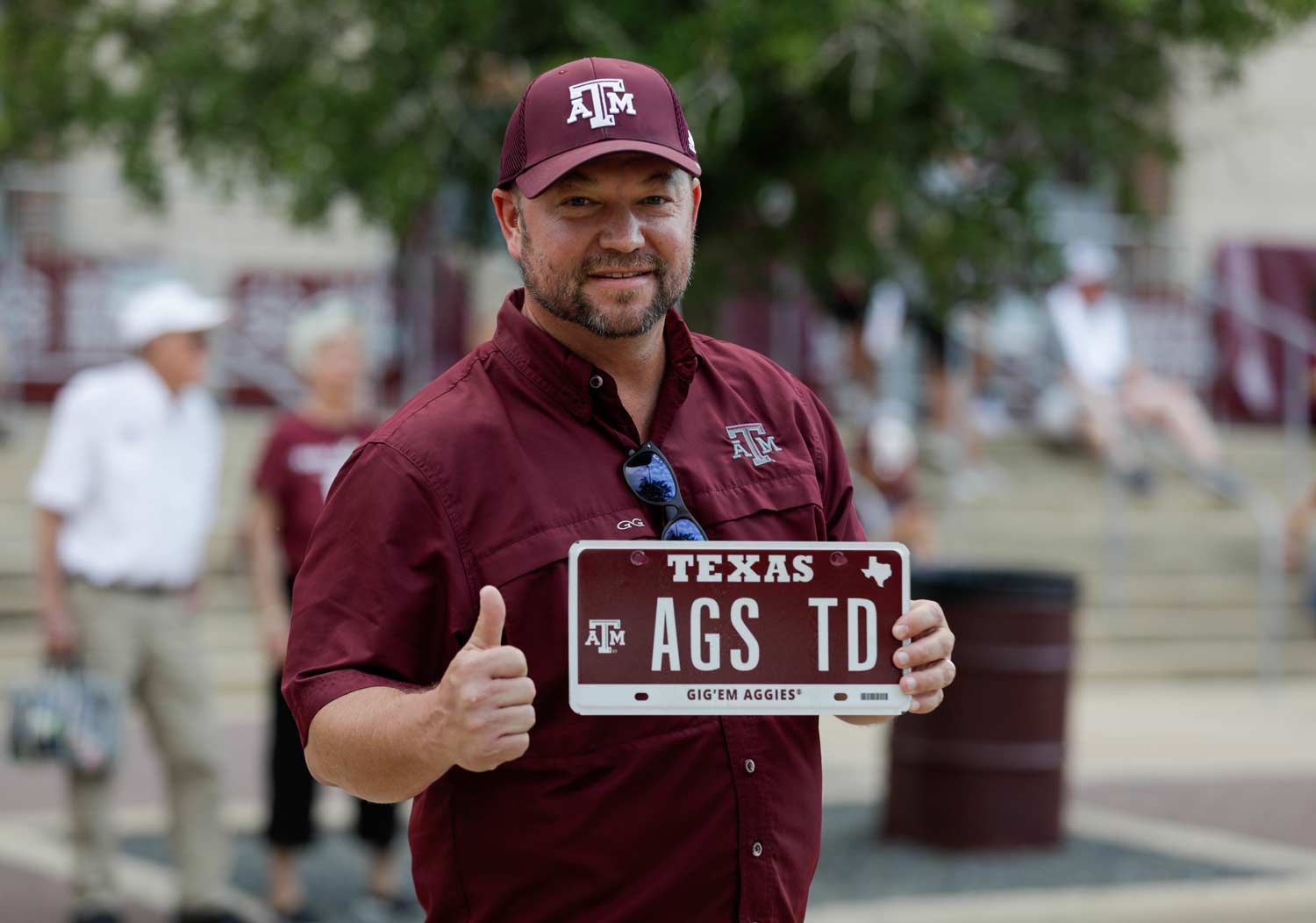 Aggie holding up his custom license plate